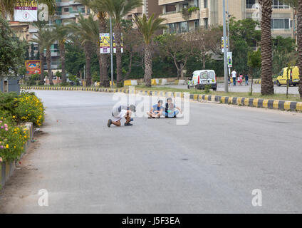 Les enfants réfugiés syriens de prendre des photos au milieu d'une route, le gouvernorat du Nord, Tripoli, Liban Banque D'Images