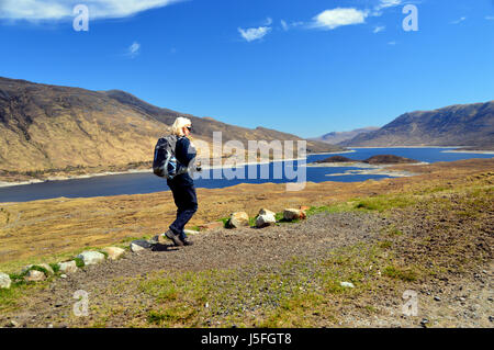 Femme seule Hillwalker marche sur la vieille route d'Tomdoun près de Loch Cluanie Glen Shiel, Kintail, N/W Scottish Highlands, Ecosse UK Banque D'Images