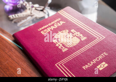 Passeport espagnol à côté de touches et l'horloge sur une table, concept Banque D'Images