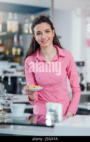 Young smiling barista servant de témoins derrière comptoir bar Banque D'Images