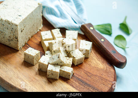 Le Tofu en tranches sur une planche de bois. L'amour pour une saine nourriture vegan concept Banque D'Images