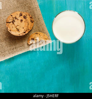 Une photo de carrés de chocolat des biscuits fraîchement cuits, tourné à partir de ci-dessus, sur un fond bleu, avec un verre de lait. Selective focus Banque D'Images