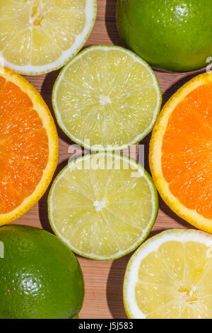 Une sélection de morceaux d'oranges, citrons et limes sur une planche de bois. Banque D'Images