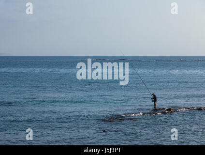 Homme libanais de la pêche sur les rochers, le gouvernorat du Sud, tire, Liban Banque D'Images