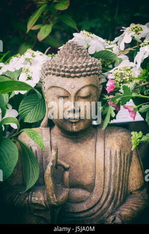 Statue de Bouddha dans le jardin un spectacle au jardin un flower show. UK. Filtre rétro vintage appliquée Banque D'Images