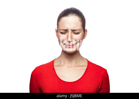 Portrait de femme en pleurs triste malheureux t-shirt rouge avec des taches de rousseur. Les yeux clos, studio shot. isolé sur fond blanc. Banque D'Images
