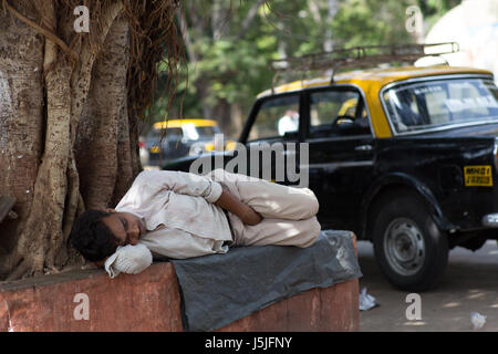 Chauffeur de taxi de prendre une sieste sur une chaude journée d'été à Mumbai, Inde. Banque D'Images