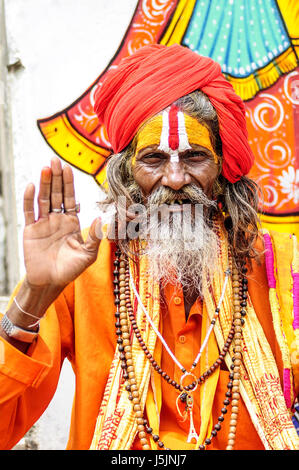 Udaipur, Inde, le 14 septembre 2010 : saint homme en oragne clothes holding sa main vers le haut. Banque D'Images