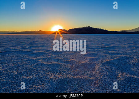 Les derniers rayons du soleil couchant illuminent le sel granulaire sur la Bonneville Salt Flats, près de la ville de Wendover, Tooele comté, le nord de l'Utah, USA. Banque D'Images