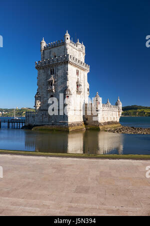 Prise de vue au grand angle de la Tour de Belém (tour de St Vincent) sur le Tage à Lisbonne avec reflet dans l'eau sur fond de ciel bleu, Portugal Banque D'Images