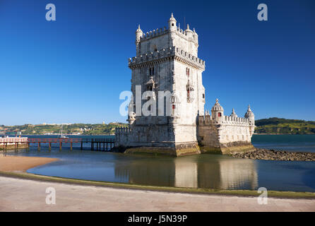 Prise de vue au grand angle de la Tour de Belém (tour de St Vincent) sur le Tage à Lisbonne avec reflet dans l'eau sur fond de ciel bleu, Portugal Banque D'Images