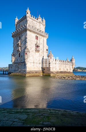 Prise de vue au grand angle de la Tour de Belém (tour de St Vincent) sur le Tage à Lisbonne avec reflet dans l'eau sur fond de ciel bleu, Portugal Banque D'Images