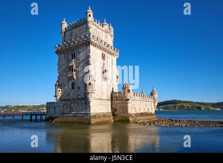 Prise de vue au grand angle de la Tour de Belém (tour de St Vincent) sur le Tage à Lisbonne avec reflet dans l'eau sur fond de ciel bleu, Portugal Banque D'Images