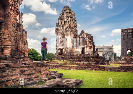 Woman in hat looking at ancient Temple en ruines de la ville de Lopburi, Thaïlande Banque D'Images