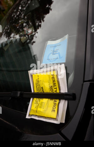 Avis de pénalité sur le pare-brise d'une voiture avec un badge handicapé, un badge de remplacement Banque D'Images