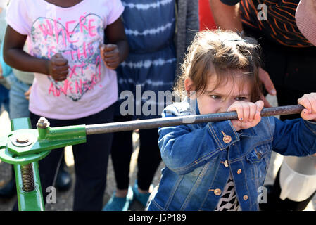 Fille poussant la poignée sur un traditionnel pour faire du jus de presse apple à Stanmer Park, Brighton, Angleterre Banque D'Images