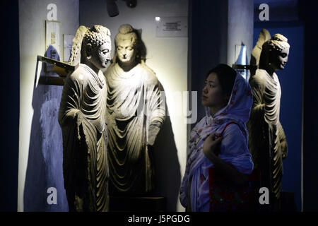 (170518) -- PESHAWAR, 18 mai 2017 (Xinhua) -- Une femme regarde une statue de Bouddha sur la Journée internationale des musées dans un musée dans le nord-ouest de Peshawar au Pakistan, le 18 mai 2017. La Journée internationale des musées est l'occasion de prendre conscience de l'importance des musées pour le développement de la société. Cette année, l'événement célébrera le thème "Musées et histoire litigieuse : Dire l'indicible dans les musées." (Xinhua/Umar Qayyum)(HR) Banque D'Images