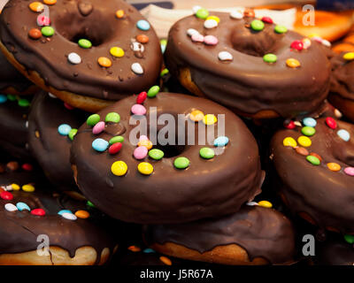 Donuts avec lustre de chocolat en vente dans une foire locale. Banque D'Images