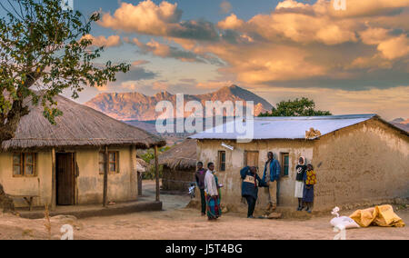 Cabane de torchis traditionnelle avec toit d'herbe plus moderne aux côtés de hut avec toit en tôle ondulée de draps dans un village rural au Malawi, l'Afrique Banque D'Images