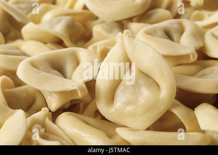 Milieux et de textures : des tortellini traditionnel, disposées en arrière-plan, résumé de l'alimentation Banque D'Images