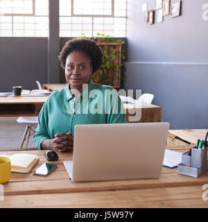 Modern African businesswoman using a laptop in a modern office Banque D'Images