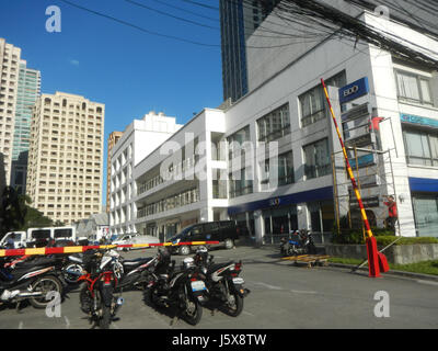 Cette photographie capture les bâtiments le long de Bagumbayan Libis à Eastwood City, Quezon City, y compris des structures notables telles que le Mercury Drug store et diverses propriétés commerciales dans la région. Banque D'Images