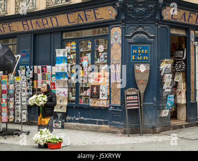 Une vieille femme vend des fleurs dans la rue devant Cafe Biard à Paris, France. Banque D'Images