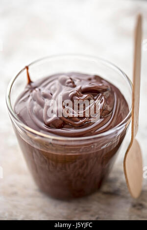 Le pouding au chocolat en verre avec cuillère en bois Banque D'Images