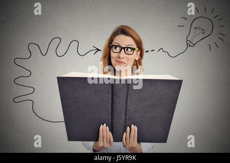 Femme lisant un livre énorme a une bonne idée Banque D'Images