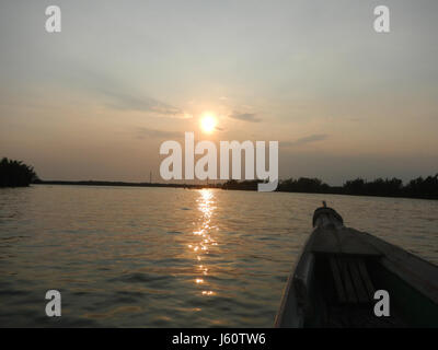Une vue sur le coucher du soleil le long des rives de Panasahan dans la ville de Malolos, Bulacan, capturant l'atmosphère tranquille et la beauté naturelle de la région. Banque D'Images
