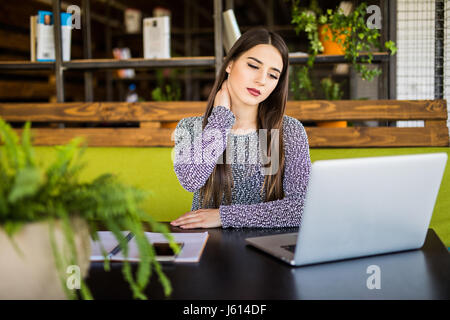 Belle femme souffrant de douleur au cou dans office Banque D'Images