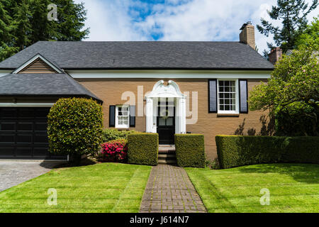 Maison moderne de brique brune et avec le joli aménagement paysager Banque D'Images