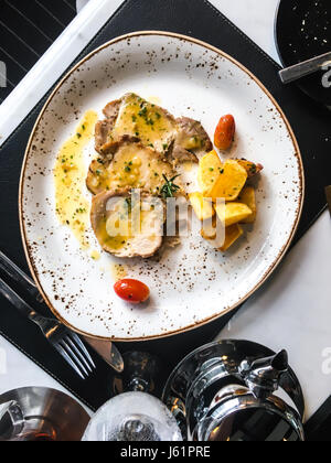 Pommes de terre au four et des tranches de viande en sauce. Studio Photo Banque D'Images