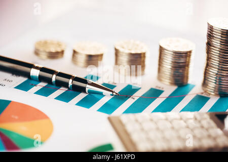 Tableau financier avec des pièces, un stylo et une calculatrice Banque D'Images
