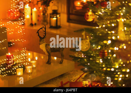 Décoration du renne dans la salle de séjour avec des bougies et l'arbre de Noël Banque D'Images