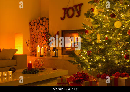 La cheminée et des bougies dans la salle de séjour avec l'arbre de Noël Banque D'Images