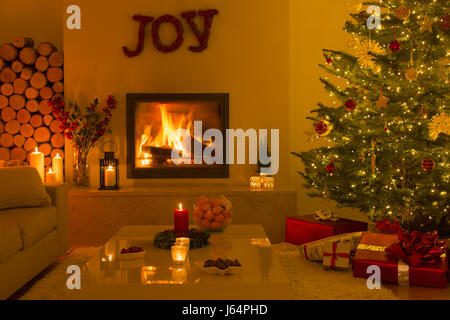 La cheminée et des bougies dans la salle de séjour avec l'arbre de Noël Banque D'Images