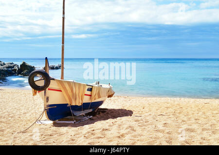 Un vieux bateau de pêche échoué dans la calme plage Platja de Sa Caleta à Lloret de Mar, sur la Costa Brava, Espagne Banque D'Images