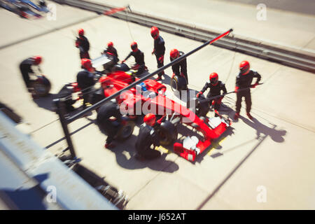 Pit Crew du remplacement des pneus de voiture de course de Formule 1 dans la voie des stands Banque D'Images