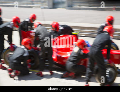 Pit Crew du remplacement des pneus de voiture de course de Formule 1 dans la voie des stands Banque D'Images