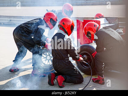 Pit Crew du remplacement des pneus de voiture de course de Formule 1 dans la voie des stands Banque D'Images