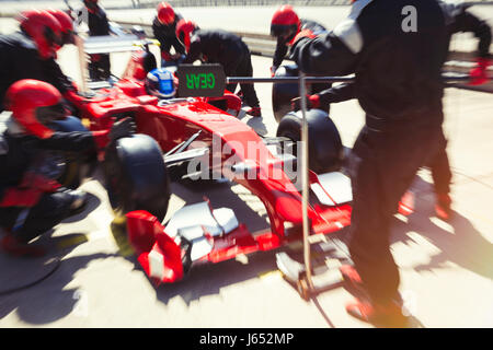 Pit Crew du remplacement des pneus de voiture de course de Formule 1 dans la voie des stands Banque D'Images