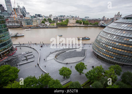 À la recherche jusqu'à la rive sud de la Tamise à Londres comme un groupe de coureurs passent par les nouveaux bâtiments. Banque D'Images