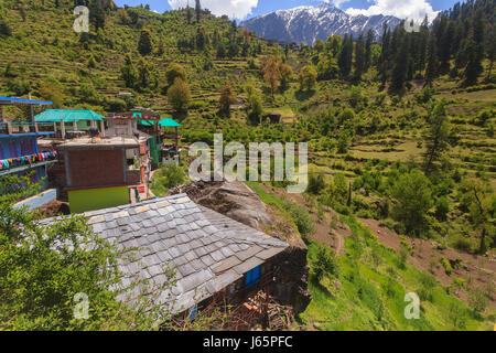 Petit village Raskat avec une maison en pierre couverte d'ardoise, surmontée de champs verdoyants et de montagnes.Situé dans la vallée de Parvati, Himachal Pradesh, Inde Banque D'Images