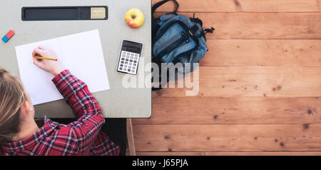 Fille assise derrière l'schooldesk Banque D'Images