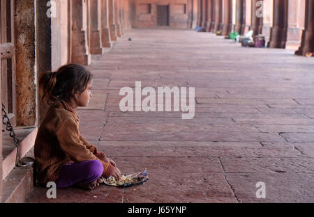 Une pauvre fille manger en Fatehpur Sikri complexe, Uttar Pradesh, Inde, 15 février 2016. Banque D'Images