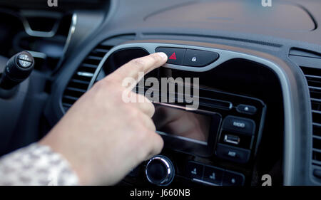 Homme de main d'urgence en appuyant sur le bouton d'alerte sur console de voiture, gros plan Banque D'Images