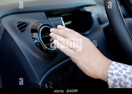 La main du pilote sur la grille de ventilation avec régulateur de puissance, contrôle de l'air de ventilation de l'air dans la voiture Banque D'Images