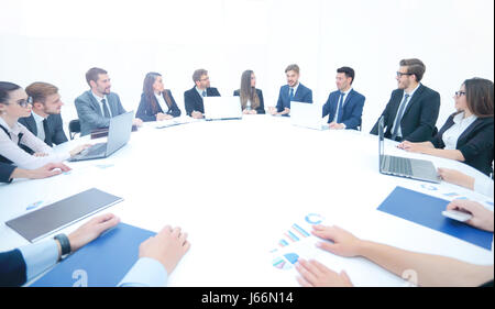 Close-up d'une grande table ronde sur laquelle sont des documents de travail et les plans financiers.Les partenaires d'affaires de discuter d'un nouveau contrat. Photo a l'espace libre Banque D'Images