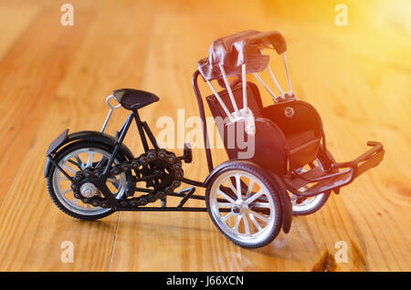 Petit jouet en bois, trois - wheeler modèle taxi tricycle sur fond de bois Banque D'Images